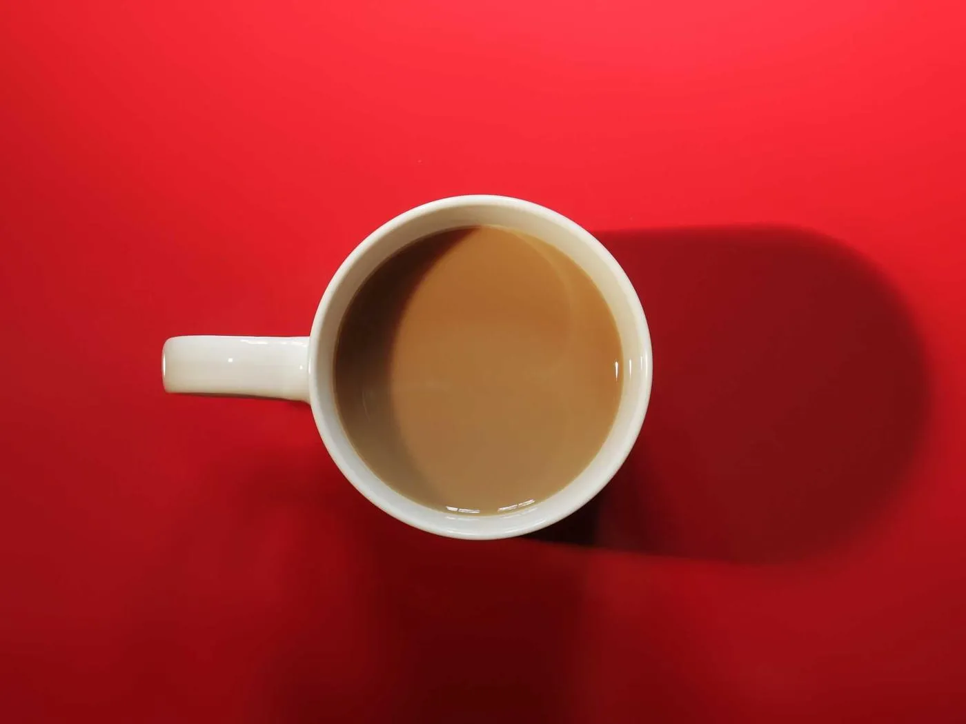 A cup of coffee on a bright red table