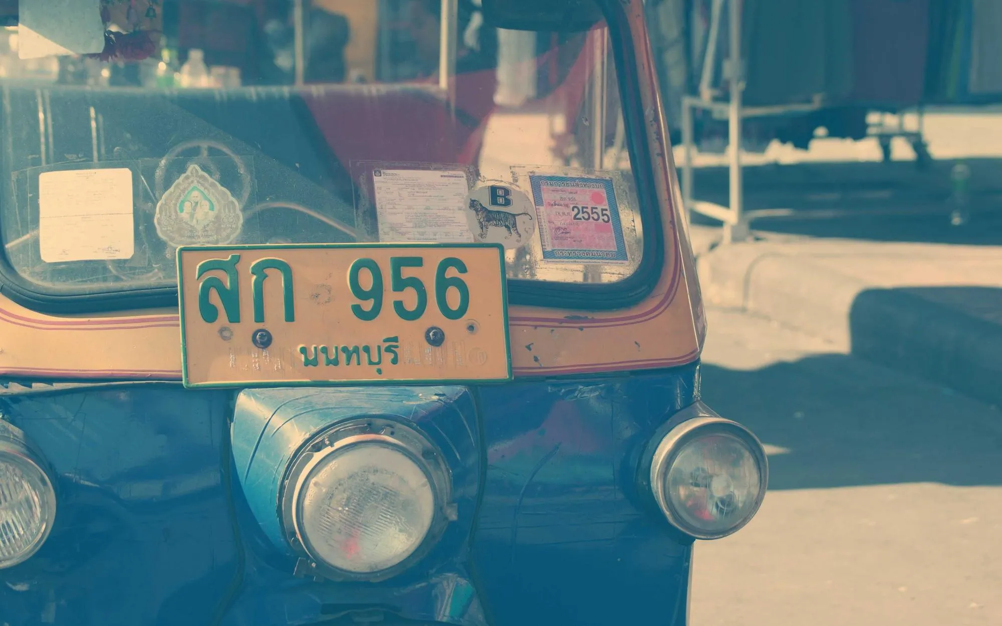 A brightly painted tuk-tuk parked on a Bangkok street